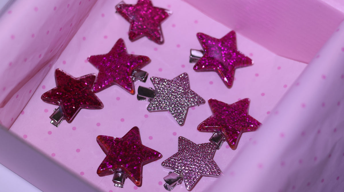 Multiple pink and silver sparkling star hair clips