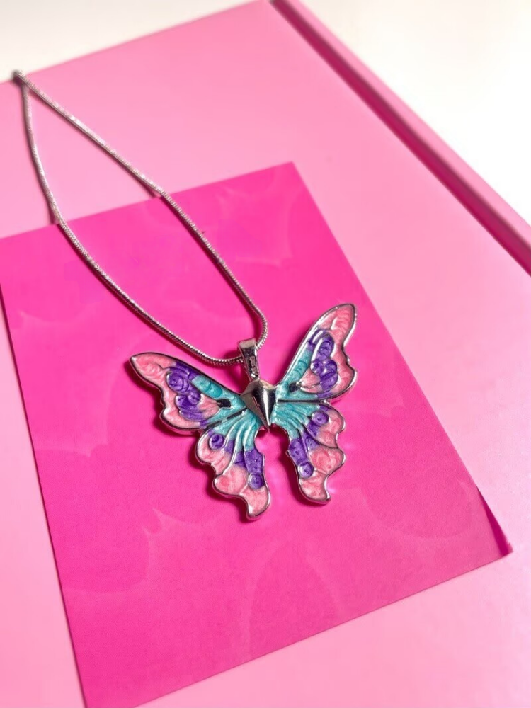 Colorful butterfly pendant necklace displayed on a pink jewelry box