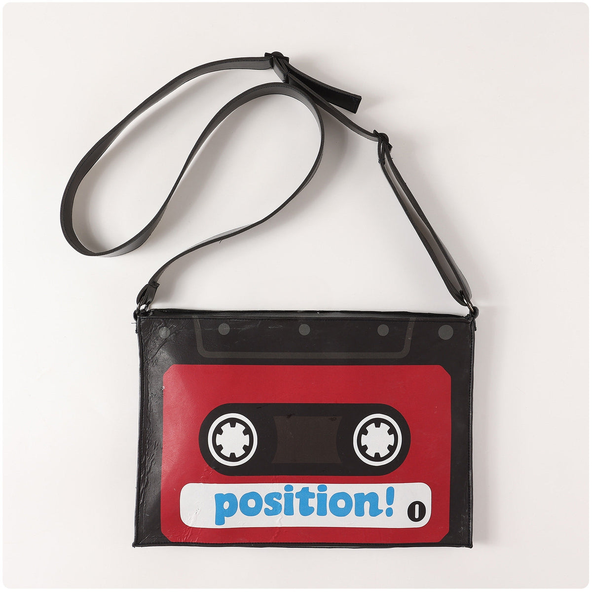 Red and black cassette-shaped crossbody bag with an adjustable shoulder strap