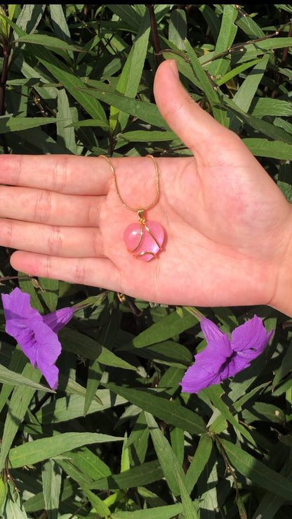 Pink heart pendant necklace displayed in hand