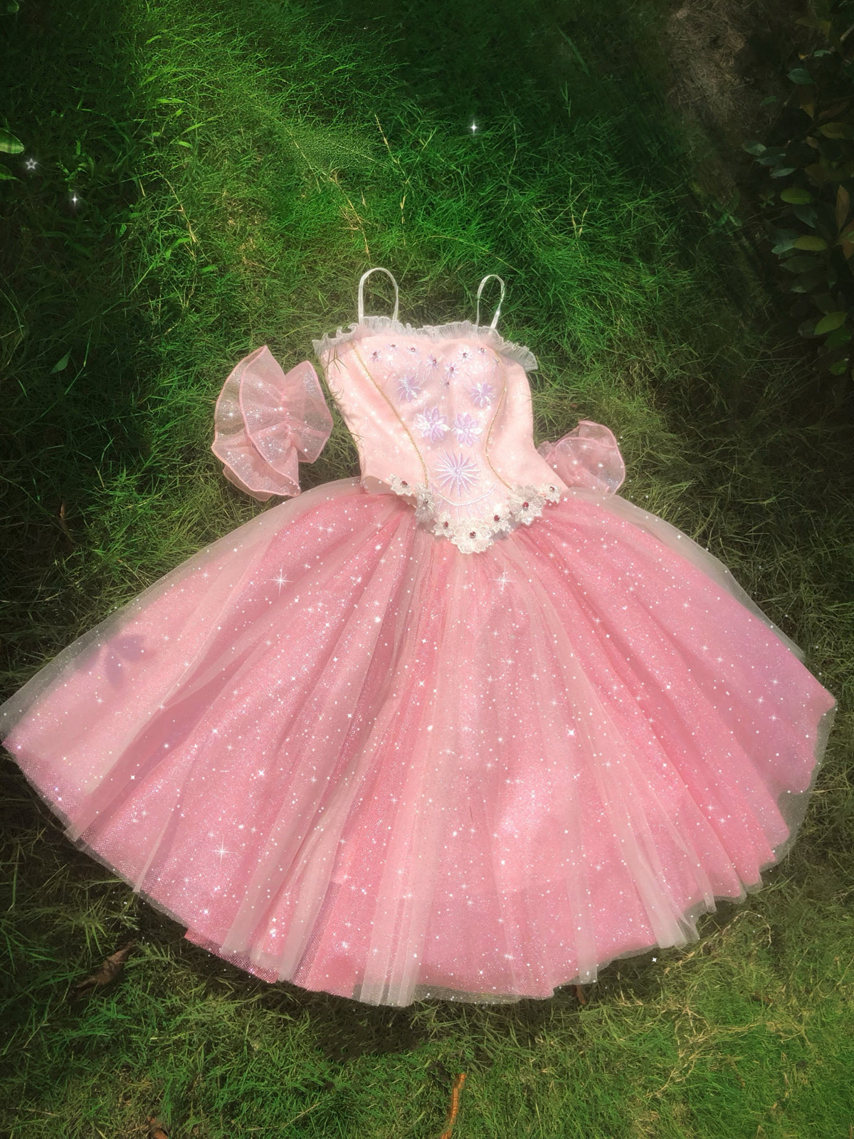 Pink Nutcracker ballet tutu costume dress displayed on grass