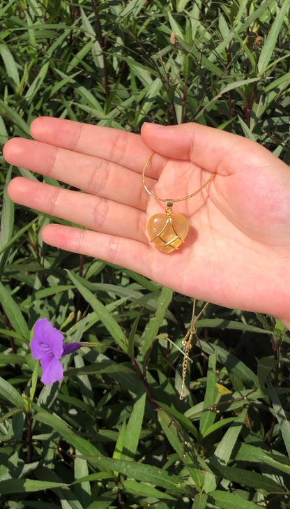 Yellow heart pendant necklace displayed in hand